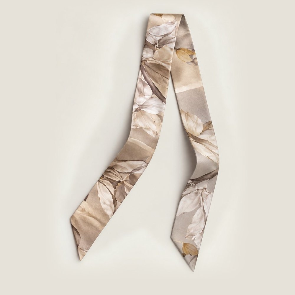 A silk twilly in sand and ivory with a leaf print